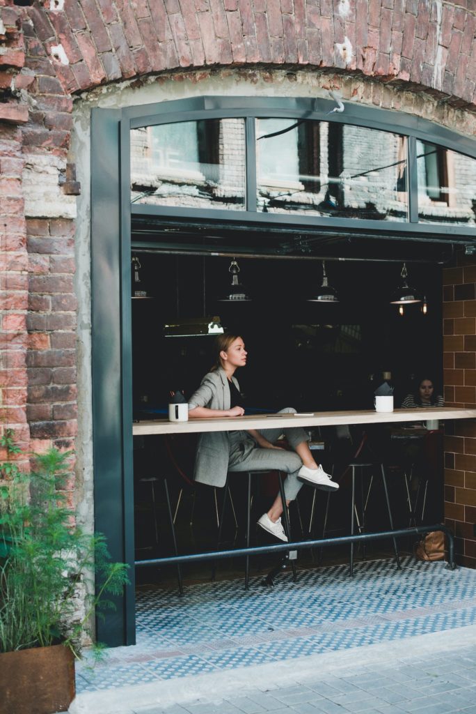 Stylish calm woman sitting at table in cafe